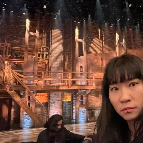 In front of a theatre set before the show