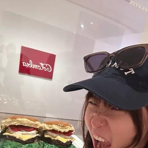 Mid-bite, in a cap and sunglasses