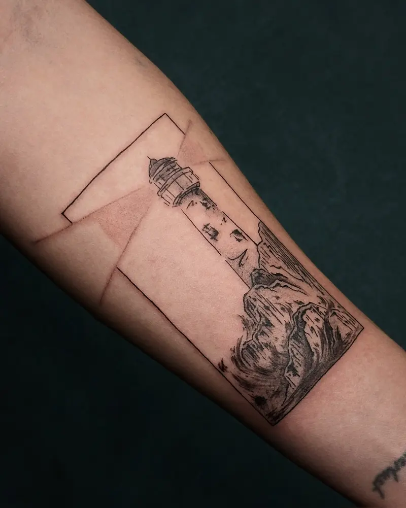 Tattoo work: a lighthouse inside a thin rectangular frame, on a forearm