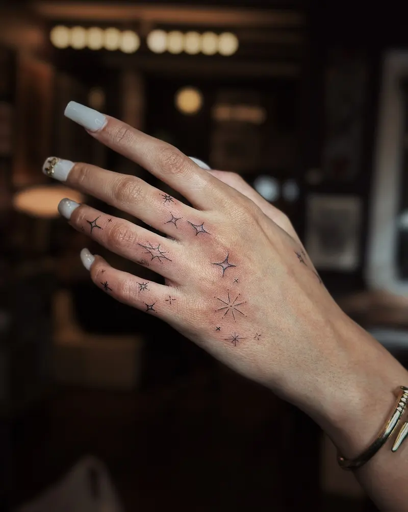 Tattoo work: a scatter of tiny fine line pieces across a hand and fingers