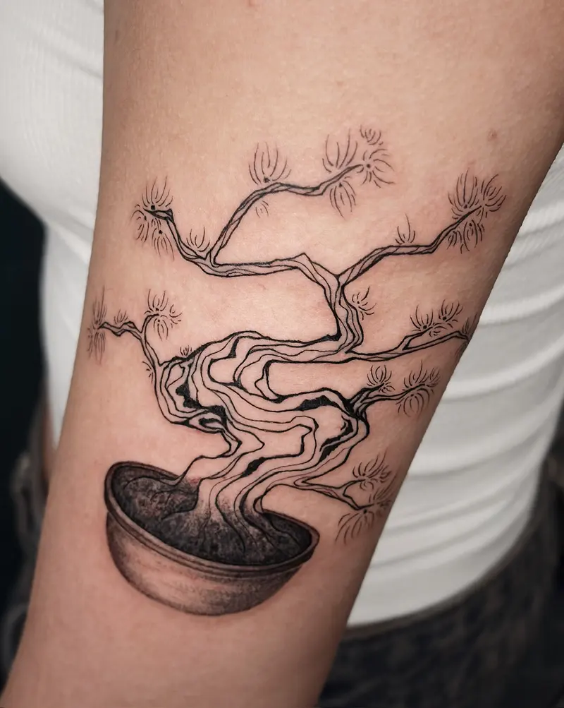 Tattoo work: a bonsai tree in a shallow pot, on an upper arm