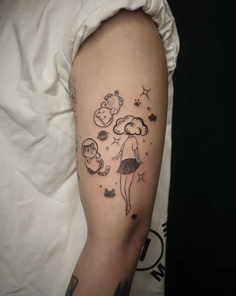 Tattoo work: a small figure among stars and clouds, on an upper arm