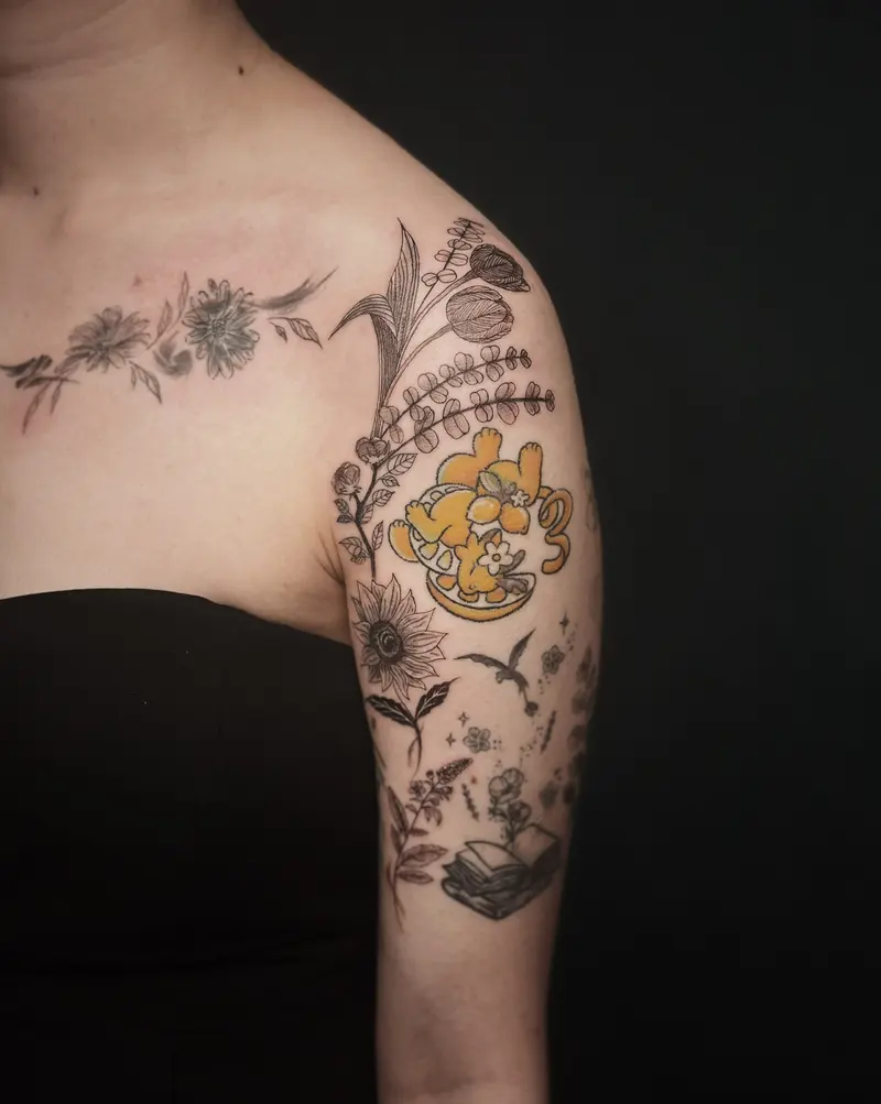 Tattoo work: florals and a small colour character across a shoulder