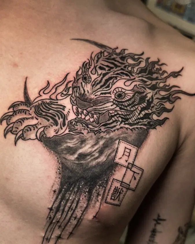 Tattoo work: a large black and grey lion with Chinese characters, across a chest
