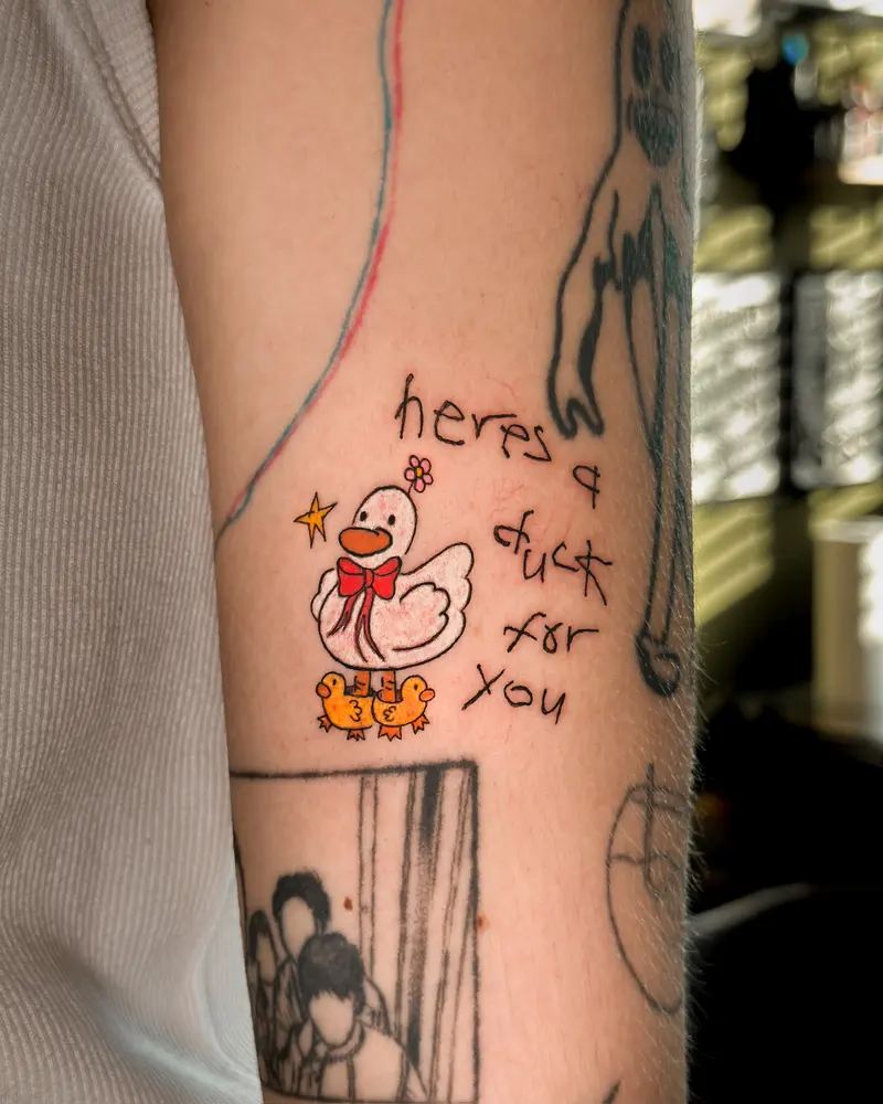 Tattoo work: a colour character with hand lettering, on an inner arm